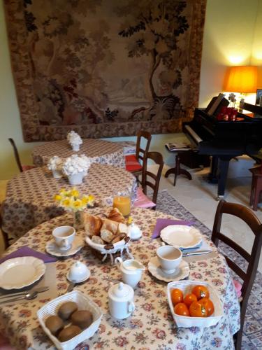 ein Tisch mit Essen darauf und ein Klavier in der Unterkunft Le Clos de Ligré in Ligré
