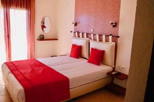 a bedroom with a large bed with red pillows at Kalntera in Ammouliani