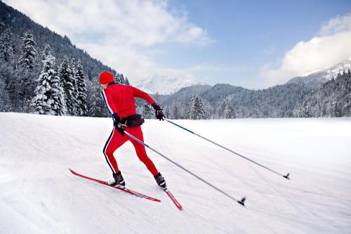 a man is skiing down a snow covered slope at JUFA Hotel Eisenerzer Ramsau in Eisenerz