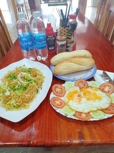 two plates of food on a wooden table at Starlet Hotel Phong Nha in Phong Nha