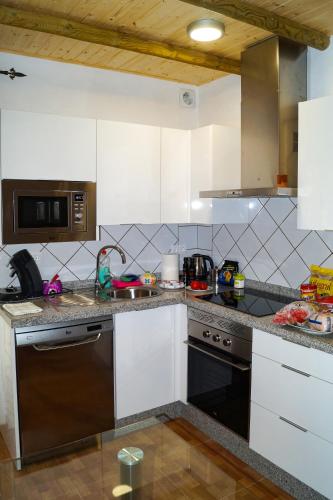 a kitchen with a sink and a stove top oven at Casa Rural El Nacimiento in Benaoján
