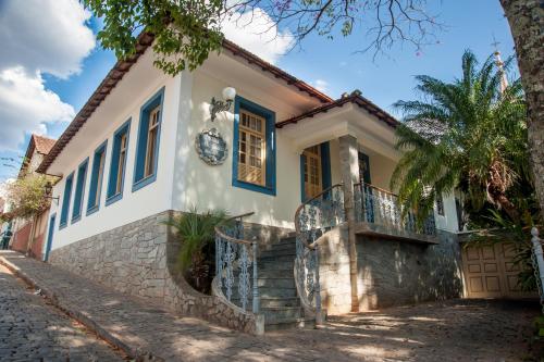 una casa con una fachada azul y blanca en Pousada Villa Magnolia, en São João del Rei