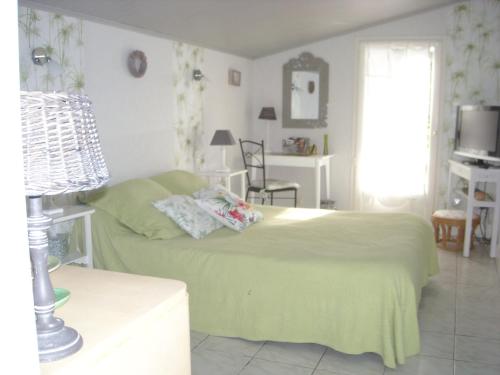 een slaapkamer met een groen bed en een bureau bij Côté Sud in Sarlat-la-Canéda