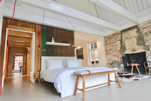 ein Schlafzimmer mit einem weißen Bett und einem Tisch in der Unterkunft Luxe Loft Bierbrouwerij het Klavertje in Dokkum