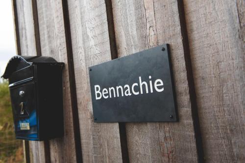 a sign on a wooden wall with the word benameidate at Clovenstone Lodges in Inverurie