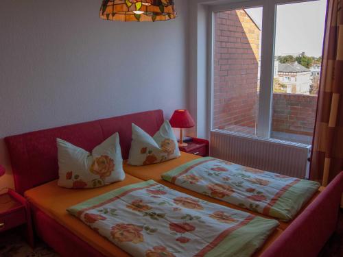 1 Schlafzimmer mit 2 Betten mit Kissen und einem Fenster in der Unterkunft 047-2 Norfolkstraße in Sande