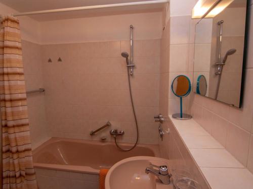 ein Bad mit einer Badewanne, einem Waschbecken und einer Dusche in der Unterkunft 047-2 Norfolkstraße in Sande