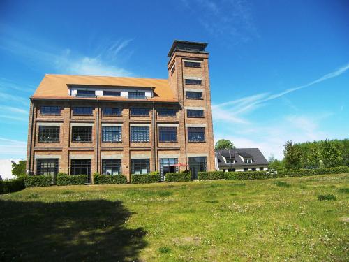 ein großes Gebäude mit einem Grasfeld davor in der Unterkunft Loft de Mar -Schlossinsel- in Wolgast