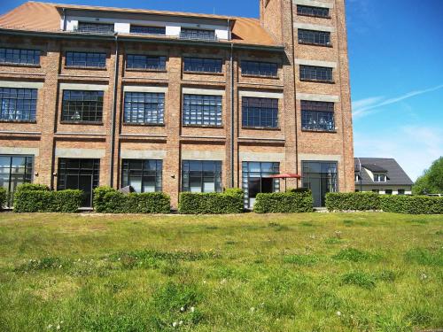 un gran edificio de ladrillo con un campo delante en Loft De Mar Schlossinsel, en Wolgast