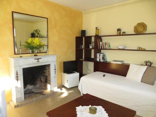 a bedroom with a bed and a fireplace and a mirror at Casa Le Bouganville in Sant Vicenç de Montalt