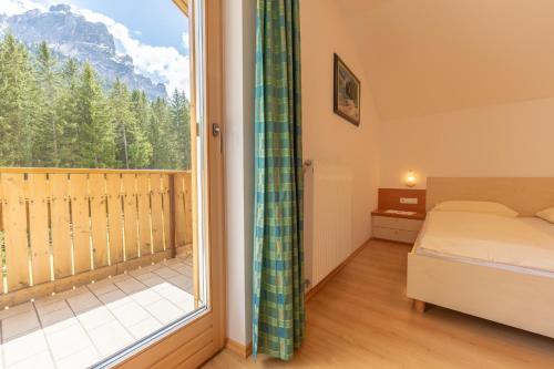 a bedroom with a bed and a large window at Residence Trenker Luis in Braies