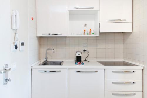 kuchnia z białymi szafkami i zlewem w obiekcie City Residence w mieście Perugia