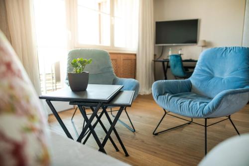 a living room with two chairs and a table at Hotel Hirzer 2781 in Avelengo