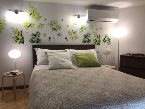 ナポリにあるCasa di Erminiaのベッドルーム1室(緑の花が飾られたベッド1台付)