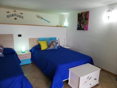 特拉比亞的住宿－Benvenuti al Sud，一间卧室配有一张带蓝色棉被的床