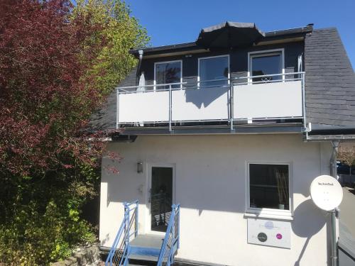 a white house with a balcony at Ferienwohnung Bergzauber 1 mit MeineCardPlus in Willingen