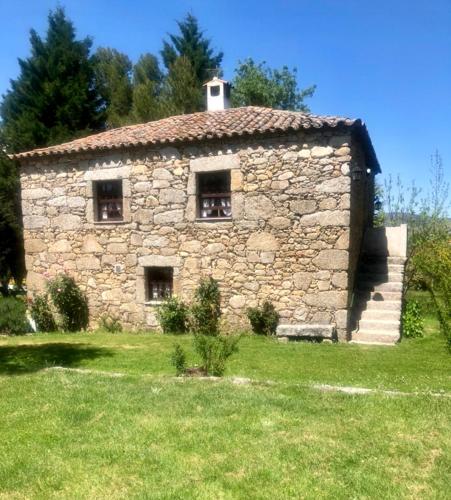 an old stone building in a field of grass at Agro-Turismo - Quinta do Pinheiro in Cavadoude