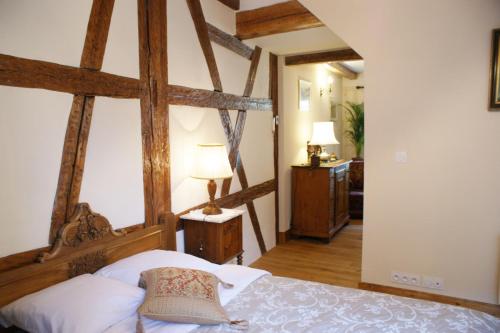 une chambre avec un grand lit avec une tête de lit en bois dans l'établissement Gîtes les bains, à Riquewihr