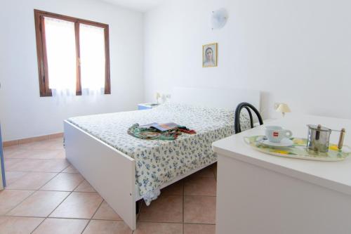 Cama en habitación con mesa y plato en Residence Villa Franca, en Capoliveri
