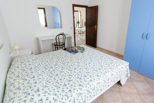 a bedroom with a bed with a blue and white comforter at Residence Villa Franca in Capoliveri