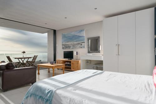 ein Schlafzimmer mit einem großen Bett und ein Wohnzimmer in der Unterkunft Camps Bay Studio Guesthouse - Studio in Kapstadt