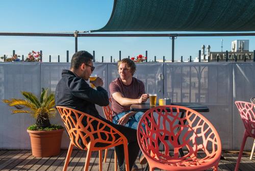 un hombre y una mujer sentados en una mesa en un patio en Safestay Barcelona Passeig de Gràcia, en Barcelona