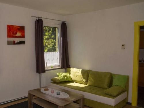 uma sala de estar com um sofá verde e uma janela em 080 Ferienwohnungen Neuengroden em Wilhelmshaven