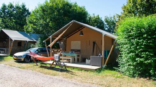 ein Haus mit einer Hängematte und einem davor geparkt in der Unterkunft Glamping Vendée in Saint-Julien-des-Landes