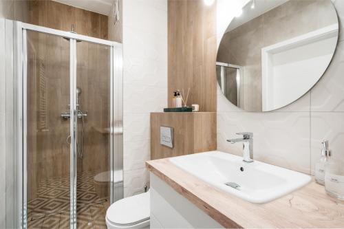 La salle de bains est pourvue d'un lavabo et d'une douche. dans l'établissement Garden Apartments by LoftAffair, à Cracovie