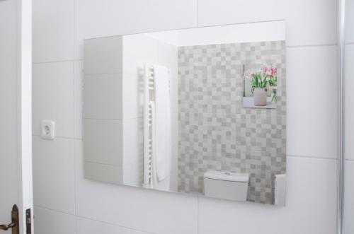 uma casa de banho com um espelho e um WC. em Casa do Relógio em Lousã