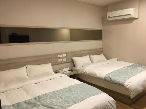 Boutique HOTEL في ليودونغ: غرفة فندقية بسريرين ومرآة