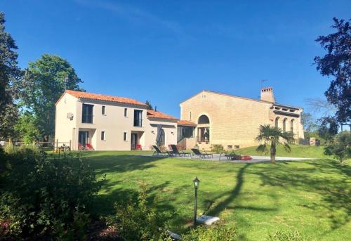 a large white house with a grass yard at L Esprit du Clain chambres d hôtes BandB de standing proches du Futuroscope Golf et Lac de St Cyr in Naintré
