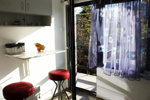 班基雅的住宿－Bankya Guest House - Sofia，窗户前带红色凳子的厨房