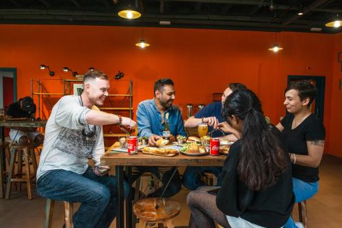 Un gruppo di persone seduti intorno a un tavolo che mangiano cibo di Safestay Barcelona Passeig de Gràcia a Barcellona
