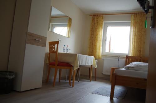 a room with a table and a chair and a window at Appartement Fleischmann in Kirchröttenbach