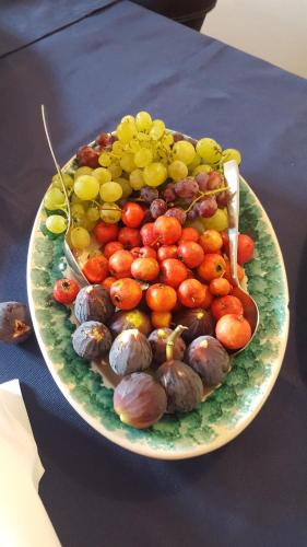 a plate of fruits and vegetables on a table at Il Casale Delle Rose in Caltagirone