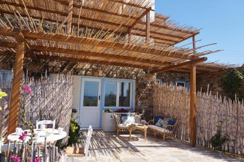 a patio with a wooden pergola and a table and chairs at KYMA Apartments - Naxos Agios Prokopios in Agios Prokopios