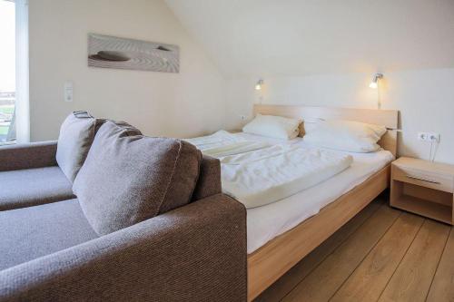 SahrensdorfにあるBuedlfarm-Nischeのソファ付きの客室の大型ベッド1台