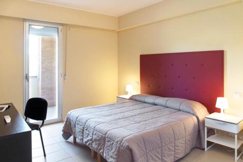 sypialnia z dużym łóżkiem z czerwonym zagłówkiem w obiekcie City Residence w mieście Perugia