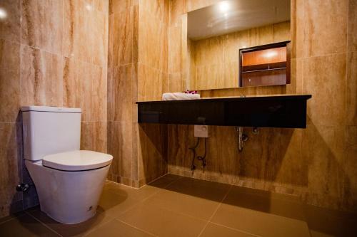 a bathroom with a toilet and a sink and a mirror at The Spa Garden in Lamai