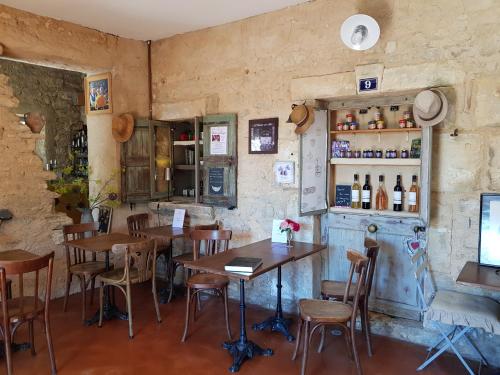 a restaurant with tables and chairs and a bar at Le Crillon in Murs