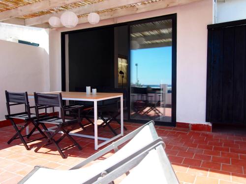 a dining room with a table and chairs on a patio at PLAYA 45, FIRST LINE BEACH HOUSE in Málaga