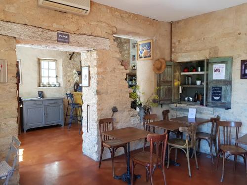 a restaurant with tables and chairs in a room at Le Crillon in Murs