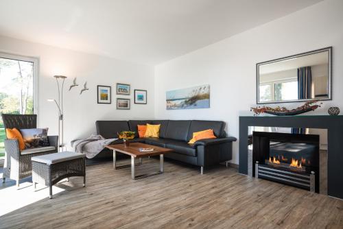 a living room with a couch and a fireplace at Appartement Seemöwe - Oase am Haff in Garz