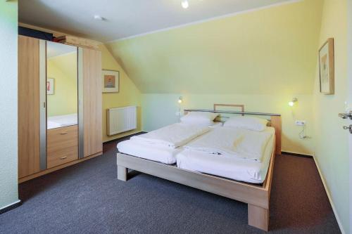 ein Schlafzimmer mit einem großen Bett mit weißer Bettwäsche in der Unterkunft Büdlfarm, Sperlings Lust in Sahrensdorf