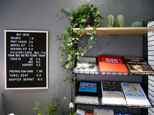 a shelf with books and a sign on a wall at The Yard Hostel in Helsinki