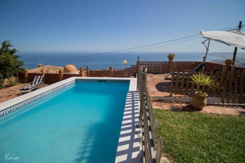 a blue swimming pool with a view of the ocean at Villa La Tuna in Benalmádena