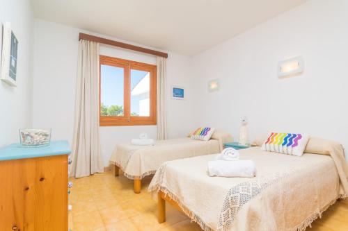 a bedroom with two beds and a window at Riandgo in Port d'Alcudia
