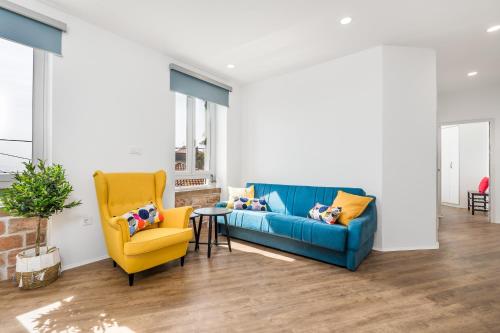 a living room with a blue couch and a yellow chair at Apartment Villa Elena in Opatija