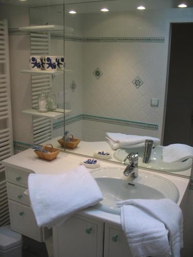 une salle de bain avec un lavabo et un miroir dans l'établissement Les charmes de Vincent - le loft Cabernet, à Fronsac